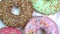 Many bright and colorful sprinkles donuts, macro shot, slowly spinning on a rotating plate