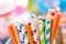 Many bright drinking straws close-up on colorful blurred background