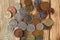 Many British coins on a beautiful wooden table.