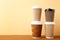 Many brown cups of coffee on beige background