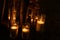 Many burning candles in glass and wooden lanterns on dark ground outdoor at night. Romantic party area. Diwali fire holiday