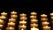 Many candle flames glowing on dark background