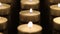 Many candle flames glowing on dark background