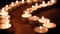 Many candle flames glowing in the dark, create a spiritual atmosphere