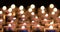 Many candles lighting in night with shallow depth of field