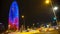 Many cars rushing by illuminated Torre Agbar, hectic night city life, time-lapse