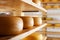 Many cheese-wheels maturing on shelves