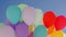 Many colorful balloons flying in blue sky background. Bunch colorful air balls flying in transparent blue sky.