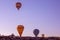 Many colorful balloons land on the goreme hills in Cappadocia in the early morning. Hot air balloon tourism