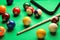 Many colorful billiard balls and cue on green table