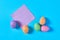 Many colorful eggs with glitters near one blank square paper sticker lies on blue desk on kitchen