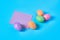 Many colorful eggs with glitters near one blank square paper sticker lies on blue desk on kitchen