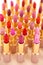 Many colorful lipstick on beige background, close up