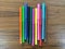 Many colorful pens placed on a wooden background