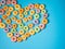 Many colorful round heart shaped sugary cereal grains on a blue background