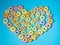 Many colorful round heart shaped sugary cereal grains on a blue background