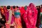 Many colorful women in sari standing in crowd