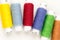 Many-coloured bobbins of thread closeup