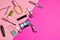 Many cosmetics objects for applying makeup on a pink background. What& x27;s in the women& x27;s cosmetic bag?