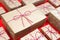 Many craft gift boxes on red background. Christmas packaging wrapped vintage paper knolling presents