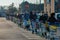 Many customers with masks waiting outside the grocery store before shopping, line of people with shopping carts in a parking lot