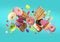 Many delicious sweets falling on dark turquoise background