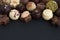 Many different chocolate bonbons on dark background with copy space