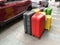 Many different colorful modern suitcases staying near car, Set of suitcases, pile of new travel suitcases luggages stacked