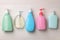Many different dispensers of liquid soap on white wooden table, flat lay