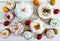Many different Easter cakes and colorful painted eggs on a white wooden background. Top view.