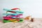 Many different flip flops and seashells on sand against white background