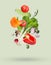 Many different fresh vegetables falling on beige background