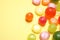Many different hard candies on yellow background, closeup. Space for text