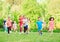 Many different kids, boys and girls running in the park on sunny summer day in casual clothes.