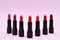 Many different lipsticks, different colors on lilac background. Space for text or design