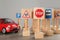 Many different miniature road signs and car on grey table, closeup. Driving school