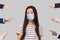 Many different people hands are pointing on guilty alone young woman with surgical medical mask and blame her. she looking at