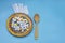 Many different pills and capsules of medicines on dark plate. Wooden spoon on light blue background. The concept of overuse