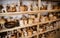 Many different pottery standing on the shelves in a pottery workshop. Low light