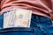 Many dollar 100 banknotes in jean pocket