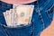 Many dollar 100 banknotes in jean pocket