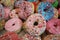 So many donuts covered with icing and colorful sugars