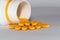 Many dose of orange medicine tablets spilling out