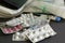 Many drugs with thermometer and blood pressure measurement device on grey background