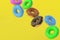 Many falling donuts on yellow background. Homemade bakery. Break time