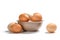 Many farm chicken eggs in a bowl on a white background.