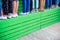 Many female legs in various shoes stand in line on a wooden green tribune