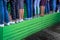 Many female legs in various shoes stand in line on a wooden green tribune