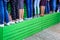 Many female legs in various shoes stand in line on a wooden green tribune