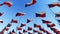 Many flags of Czech Republic in front of blue sky.